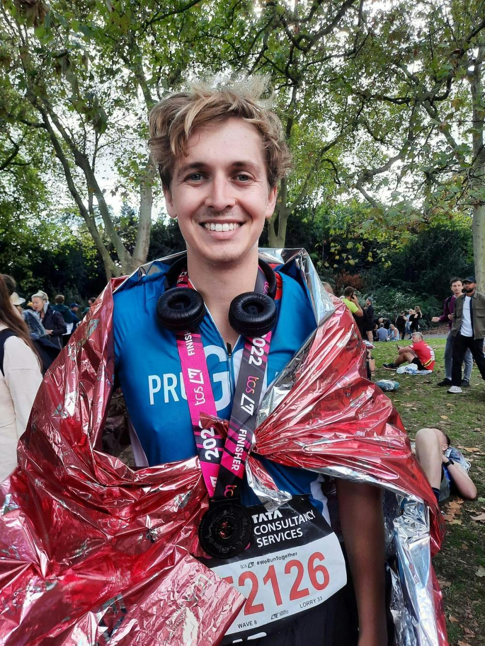 Fred smiling wearing a medal and foil blanket in running clothes