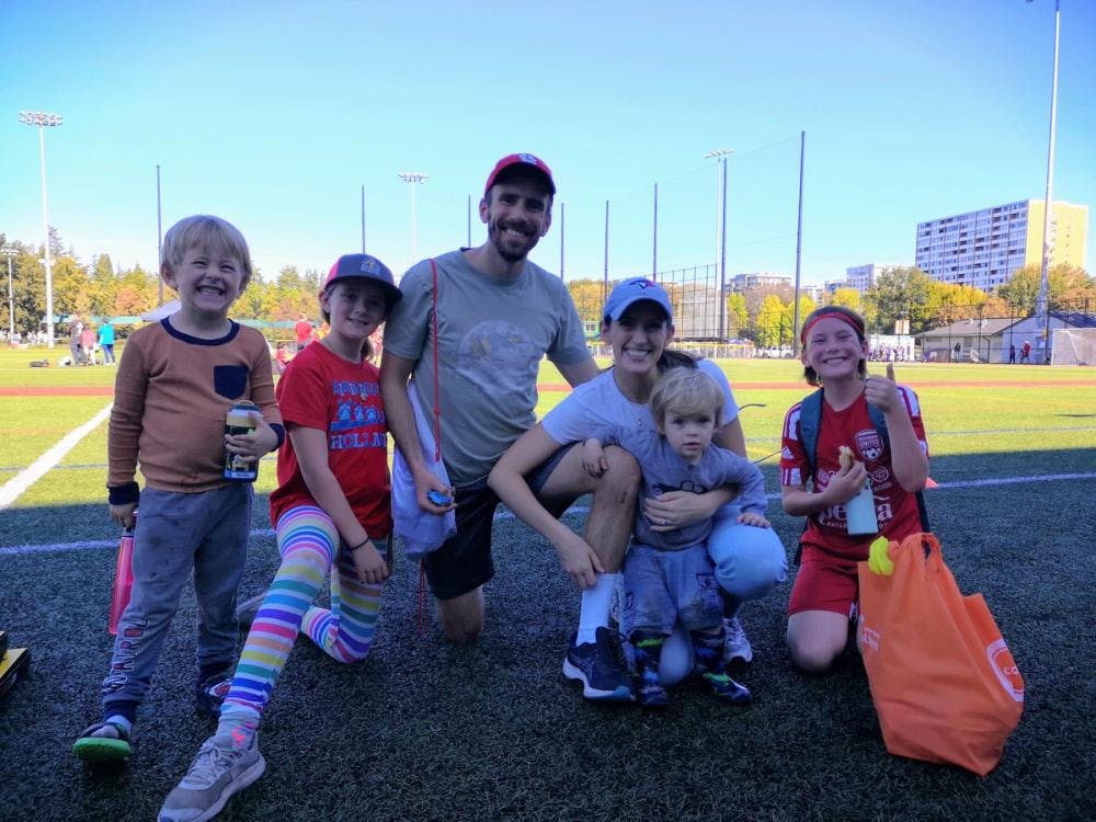 NJ, her husband, and her four children in front of a soccer field