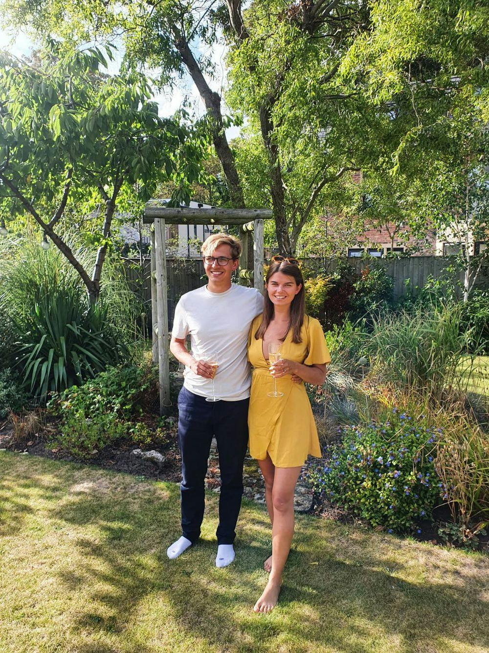 Fred and his fiance standing and smiling in a garden
